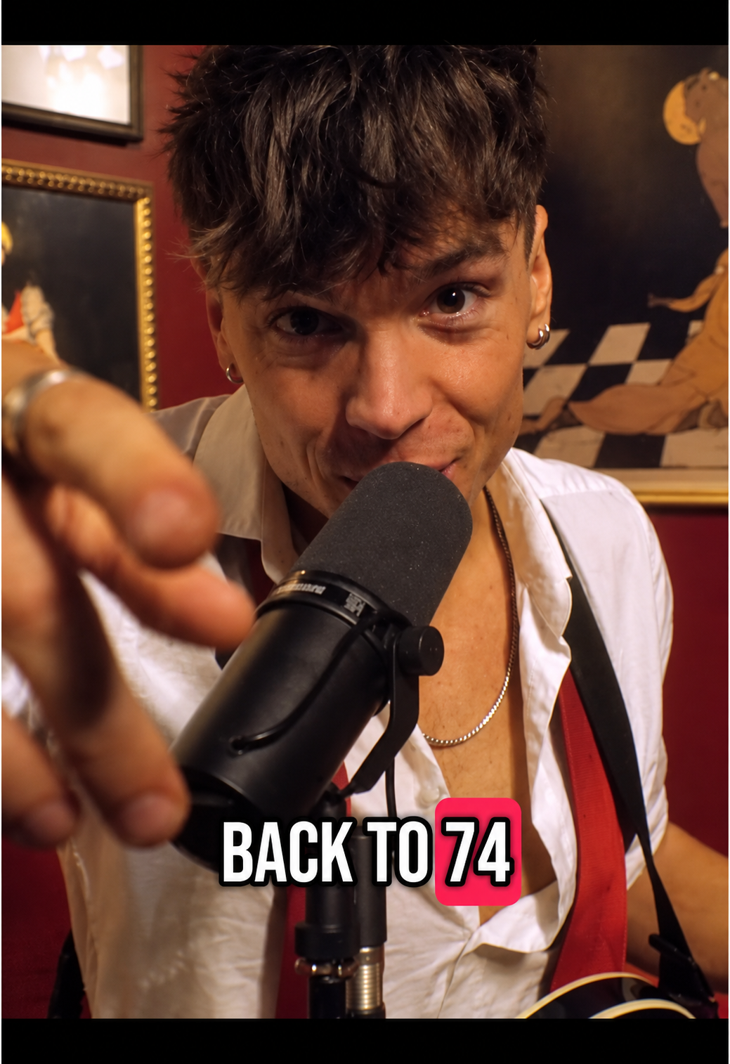 Ren pointing toward the camera while singing into the microphone — Back to 74